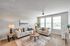 Elegant living room with modern decor, featuring plush sofas, stylish tables, and large windows for abundant natural light.