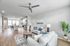 Bright, modern open-concept living room and kitchen with stylish decor, featuring cozy sofas, chic dining area, and vibrant greenery.
