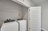 Modern laundry area with sleek Whirlpool washer and dryer, featuring convenient shelving and elegant white door for space efficiency.