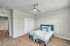 Bright and airy bedroom with sleek wood flooring, modern ceiling fan, and stylish double closet doors.