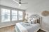 Bright and airy bedroom featuring elegant decor, a plush bed with soft cushions, and large windows offering scenic views.