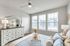 Bright and elegant bedroom with large windows, chic furniture, and stylish decor, perfect for a cozy retreat.