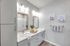 Modern bathroom with elegant double vanity, stylish lighting, and chic decor.