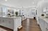 Elegant open-concept living area with a modern kitchen island, cozy seating, and abundant natural light, perfect for stylish living.