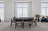 Elegant lounge area with a poker table, stylish seating, and large windows offering ample natural light.