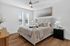 Elegant bedroom featuring a plush king-size bed, chic decor, and abundant natural light from large windows.