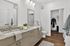 Modern bathroom with granite countertops, dual sinks, and sleek storage. Inviting walk-in closet and elegant wooden flooring.