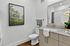 Elegant bathroom with modern fixtures, granite countertop, artwork, and chic decor for a contemporary feel.