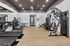 Modern gym with state-of-the-art fitness equipment including treadmills, ellipticals, and strength machines on elegant wood flooring, perfect for an invigorating workout.