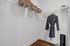 Spacious walk-in closet with elegant wire shelving, showcasing sleek storage baskets, plush robe, and fitness essentials.
