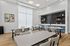 Bright and modern community room with sleek tables, contemporary art, and a chic kitchenette, perfect for gatherings.