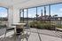 Bright and airy screened porch with stylish patio furniture, offering serene views of palm trees and landscaped outdoors, perfect for relaxation.