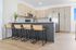 Modern kitchen with sleek cabinets, granite countertops, and stylish bar stools, perfect for entertaining.