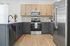 Modern kitchen with sleek stainless steel appliances, elegant two-tone cabinetry, and granite countertops accented by a stylish backsplash.