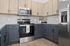 Modern kitchen with sleek stainless steel appliances, two-tone cabinetry, and elegant granite countertops.