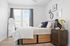 Bright and cozy bedroom with elegant decor, featuring a stylish wooden bed, modern side table, and decorative wall art.
