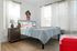 Charming bedroom with modern decor, showcasing large windows, cozy textiles, and vibrant accents for a fresh, inviting atmosphere.