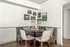 Charming dining nook with a round table, cushioned seats, and framed artwork on the wall.