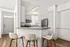 Bright modern kitchen with sleek white cabinets, stainless steel appliances, and a chic breakfast bar with stylish stools.