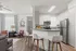 Sleek modern apartment featuring an open kitchen with bar seating, stylish living area with laminate flooring, and natural light.
