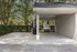 Clean and covered outdoor car washing area with essential amenities surrounded by lush greenery.