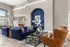 Bright and spacious living room with plush navy sofas, modern artwork, and leather chairs.