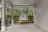 Covered outdoor wash station with stainless steel sink, surrounded by lush greenery.