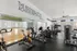 Modern fitness center with exercise equipment and motivational quote on the wall.