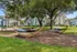 Scenic view of a peaceful apartment community park with hammocks and a playground.