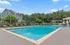 Elegant outdoor pool area with lounge chairs and lush surroundings at a modern apartment complex.