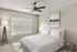 Elegant bedroom with a modern ceiling fan, large window, and stylish decor.