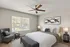 Cozy bedroom with a queen-sized bed, stylish armchair, ceiling fan, and large window offering a beautiful outdoor view.