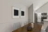 Elegant dining area with modern artwork and view into a sleek kitchen with stainless steel appliances.