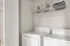 Elegant laundry room featuring a washer and dryer with overhead storage baskets.