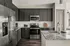 Modern kitchen with sleek dark cabinets, stainless steel appliances, and granite countertops.