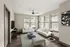 Bright and inviting modern living room featuring sleek white sofas, stylish glass coffee table, and large windows offering natural light.