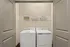 Modern laundry area featuring a washer and dryer with overhead shelving for organization.