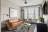 Stylish living room featuring a tan leather sofa, elegant glass coffee table, and modern decor.
