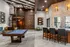 Stylish recreation room with a pool table, spiral staircase, and modern lighting features.