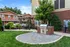 Inviting apartment patio with a barbecue grill, wooden pergola, and seating area.