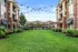 Charming apartment exterior with well-maintained gardens and string lights overhead.