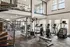 Bright, spacious fitness center with cardio machines, weightlifting equipment, and a spiral staircase.