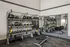 Modern fitness room with TRX equipment, kettlebells, and gym mirrors, designed for versatile workouts.