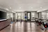 Bright and spacious gym featuring cycling machines, rowing equipment, and fitness balls.