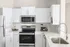 Contemporary kitchen with stainless steel appliances, white cabinetry, and modern fixtures.