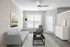 Elegant living room with modern gray sofa, chic floor lamp, and stylish decor, featuring natural light and a sleek ceiling fan.