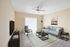 Elegant living room with modern furniture, featuring a sleek gray sofa, stylish armchair, and minimalist decor.