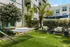 Inviting outdoor garden space with a hammock, plush seating, and tropical greenery at a modern apartment complex.