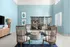 Modern lounge with stylish wooden chairs, artistic decor, and a calming blue palette.