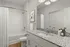 Contemporary bathroom with granite countertop, white cabinetry, and tiled shower.